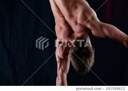 circus artist keeps balance on one hand isolated on a black background. concept of handstand and calisthenic circus artist keeps balance on one hand isolated on a black background. concept of handstand and calisthenic 101509812