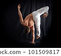 circus artist keeps balance on one hand isolated on a black background. concept of handstand and calisthenic 101509817