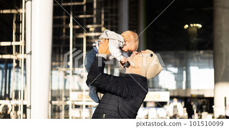 Father happily holding and lifting his infant baby boy child in the air after being rejunited in front of airport terminal station. Baby travel concept Father happily holding and lifting his infant baby boy child in the air after being rejunited in front of airport terminal station. Baby travel concept 101510099
