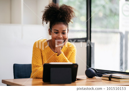 African american student woman in sweater using digital tablet t 101510153