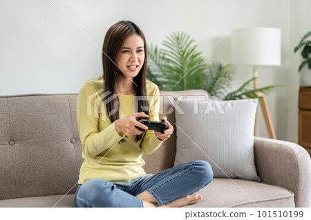 Young asian woman is using video game control joystick to playin Young asian woman is using video game control joystick to playin 101510199