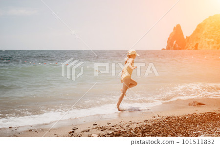 Cute little girl running along the seashore against a clear blue sea and rejoices in the rays of the summer sun. Beautiful girl in yellow swimsuit running and having fun on tropical beach. Cute little girl running along the seashore against a clear blue sea and rejoices in the rays of the summer sun. Beautiful girl in yellow swimsuit running and having fun on tropical beach. 101511832