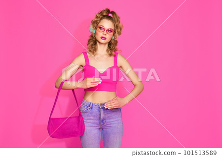 Portrait of attractive woman wearing glam clothes and listening music over pink studio background. Standing like doll 101513589