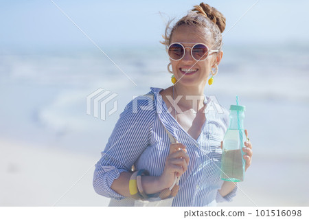 Portrait of smiling elegant woman with drink at beach Portrait of smiling elegant woman with drink at beach 101516098
