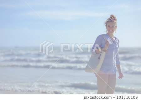 smiling elegant woman with white straw bag at beach 101516109