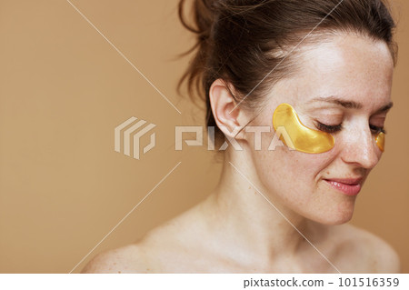 happy modern female with eye patches against beige background 101516359
