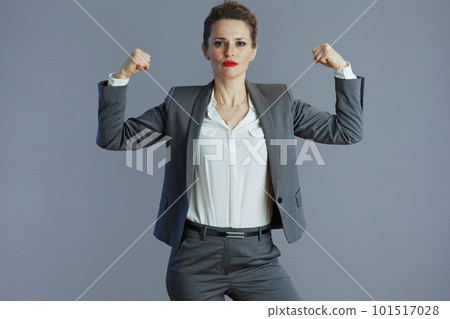 strong stylish business owner woman showing biceps against grey strong stylish business owner woman showing biceps against grey 101517028