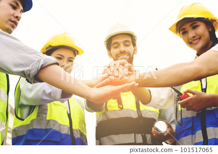 Group of contractors, engineers and formats in safety vests with helmets join hands to work together to successfully complete a construction project on construction site. cooperation and success Group of contractors, engineers and formats in safety vests with helmets join hands to work together to successfully complete a construction project on construction site. cooperation and success 101517065