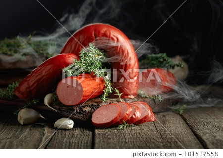 Smoked sausage with thyme and garlic on a wooden table. Smoked sausage with thyme and garlic on a wooden table. 101517558