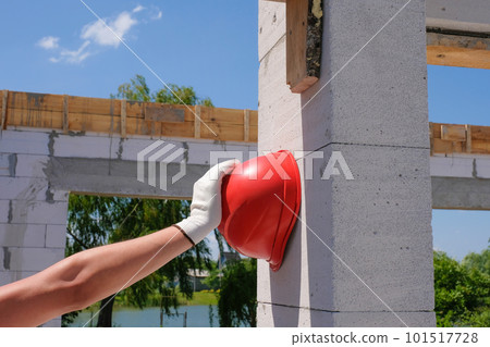 Safety helmet in the hand of a worker at a construction site. Safety concept 101517728
