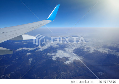 View of the wing of an airplane over the snowy mountains. Beautiful landscape 101517850