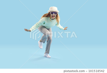 Cheerful crazy young woman laughs and dances cheerfully on light blue background. Cheerful crazy young woman laughs and dances cheerfully on light blue background. 101518542