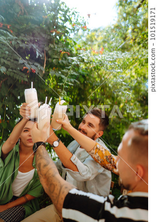 Summer milkshake. Young friends celebrating summer and drinking milkshakes in a cafe. Summer milkshake. Young friends celebrating summer and drinking milkshakes in a cafe. 101519171