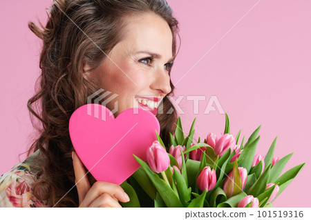smiling trendy 40 years old woman in floral dress on pink smiling trendy 40 years old woman in floral dress on pink 101519316