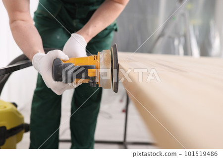 Carpenter processes wooden table with grinder machine Carpenter processes wooden table with grinder machine 101519486