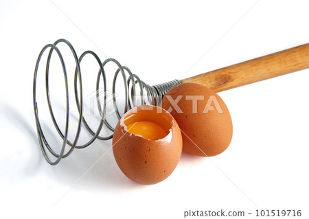 Two beige chicken eggs and a rare eggbeater for beating. Ingredients for cooking isolated on white background 101519716
