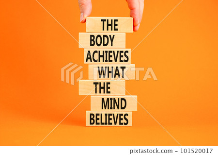 Mind and body symbol. Concept words The body achieves what the mind believes on wooden blocks. Beautiful orange background. Copy space. Businessman hand. Motivational mind and body concept. Mind and body symbol. Concept words The body achieves what the mind believes on wooden blocks. Beautiful orange background. Copy space. Businessman hand. Motivational mind and body concept. 101520017