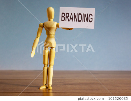 Wooden model of a man holding a tablet saying branding. Wooden model of a man holding a tablet saying branding. 101520085