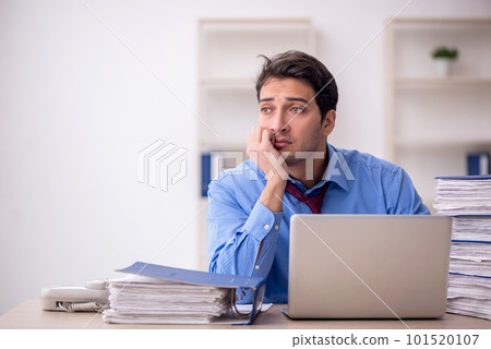 Young male employee and too much work in the office Young male employee and too much work in the office 101520107