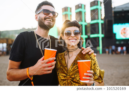Lovely couple having fun at festival. Young friends with beer at beach party. Summer holiday, vacation. Lovely couple having fun at festival. Young friends with beer at beach party. Summer holiday, vacation. 101520169