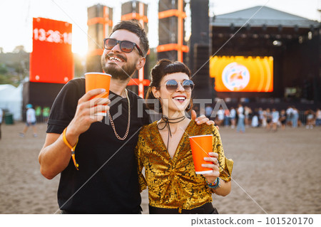 Lovely couple having fun at festival. Young friends with beer at beach party. Summer holiday, vacation. 101520170