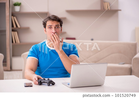 Young man playing video games at home Young man playing video games at home 101520749