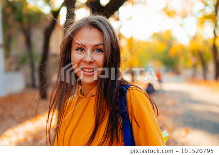 Portrait of a happy smiling young woman while walking outdoors 101520795
