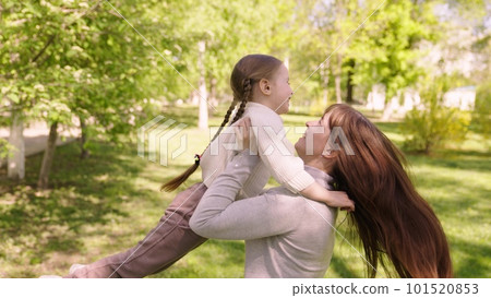 happy family. mom hugs child girl daughter park. cheerful girl spinning her mother arms. happy child. child dream mom. kid laughs his mother arms park. happy family concept. child runs green grass happy family. mom hugs child girl daughter park. cheerful girl spinning her mother arms. happy child. child dream mom. kid laughs his mother arms park. happy family concept. child runs green grass 101520853