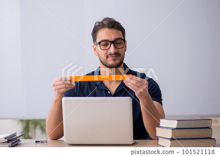 Young male teacher in telestudying concept 101521118
