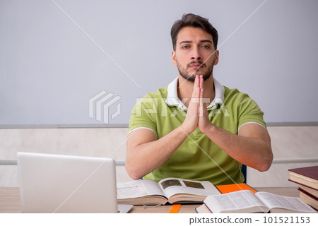 Young male student sitting in front of whiteboard Young male student sitting in front of whiteboard 101521153