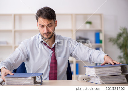 Young male employee sitting at workplace 101521302