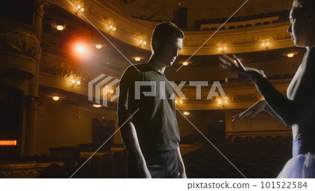 Ballerina with partner stands on theater stage Ballerina with partner stands on theater stage 101522584