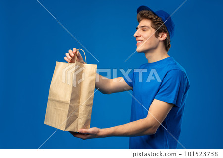 Food delivery man holding a paper box on blue background 101523738