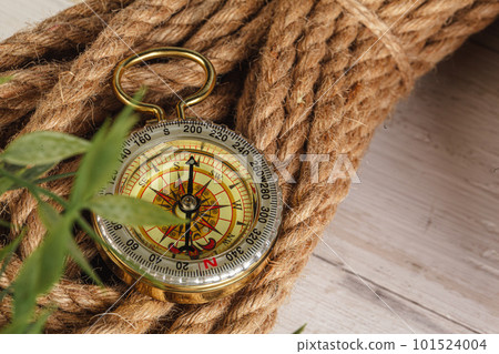 Compass surrounded by mountain gear tools on wooden background 101524004