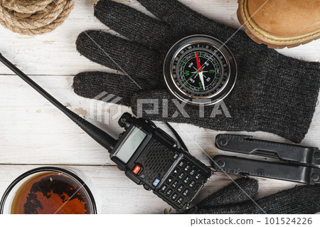 Hiking boots with equipment for hiking, cup of tea on wooden board 101524226