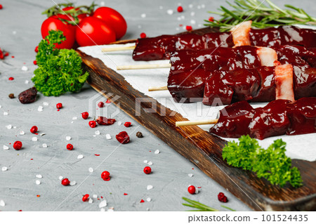 Raw liver kebab on skewers on wooden board Raw liver kebab on skewers on wooden board 101524435