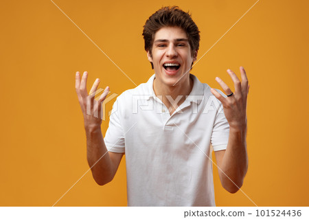 Portrait of a satisfied young man celebrating success over yellow background 101524436