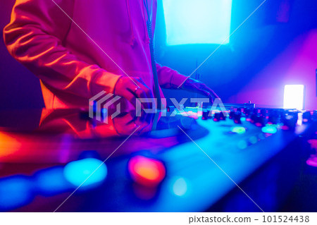 Hands of a DJ creating and regulating music on dj console mixer at club concert Hands of a DJ creating and regulating music on dj console mixer at club concert 101524438