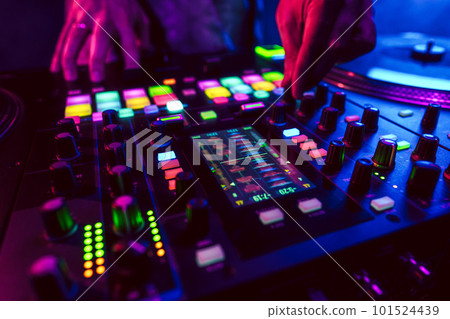 Close up of DJ hands on dj console mixer during concert in the club 101524439