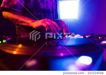 Close up of DJ hands on dj console mixer during concert in the club Close up of DJ hands on dj console mixer during concert in the club 101524588