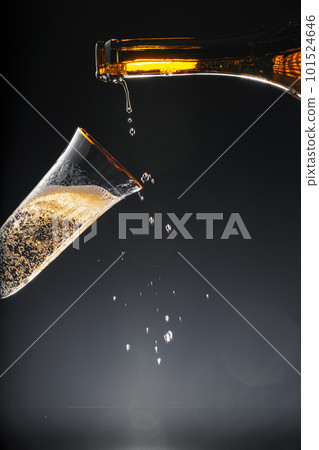 Champagne pouring into glass on black background 101524646