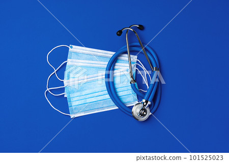 Medical face masks and stethoscope on blue background 101525023