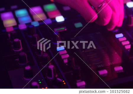 Hands of a DJ creating and regulating music on dj console mixer at club concert Hands of a DJ creating and regulating music on dj console mixer at club concert 101525082