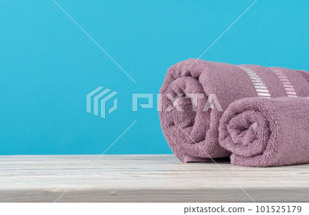 Stack of rolled towels on a wooden table 101525179