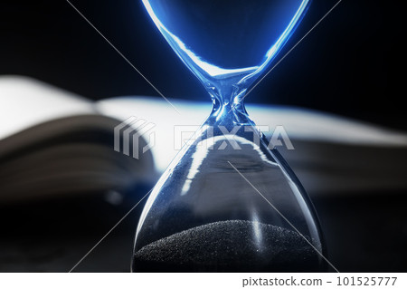 Closed up of sandglass or hourglass on background of book 101525777
