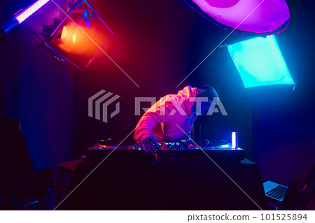 Male DJ playing music in the night club 101525894