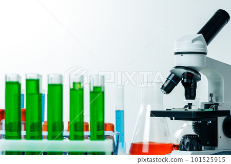 Laboratory microscope with colorful test tubes close up 101525915