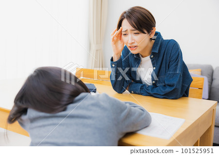 Elementary school students and mothers doing homework in the living room 101525951