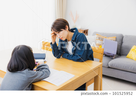 Elementary school students and mothers doing homework in the living room 101525952