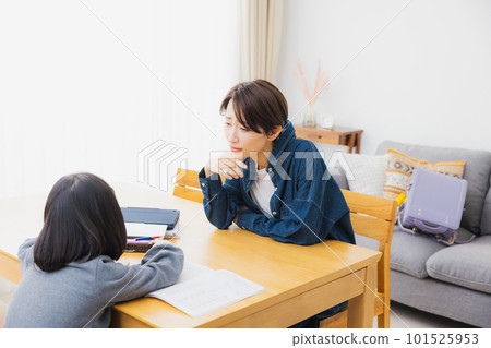 Elementary school students and mothers doing homework in the living room 101525953